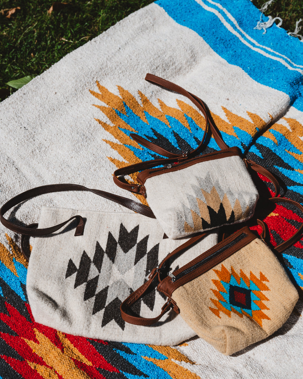 Mexican wool purses laying on top of a handwoven mexican blanket