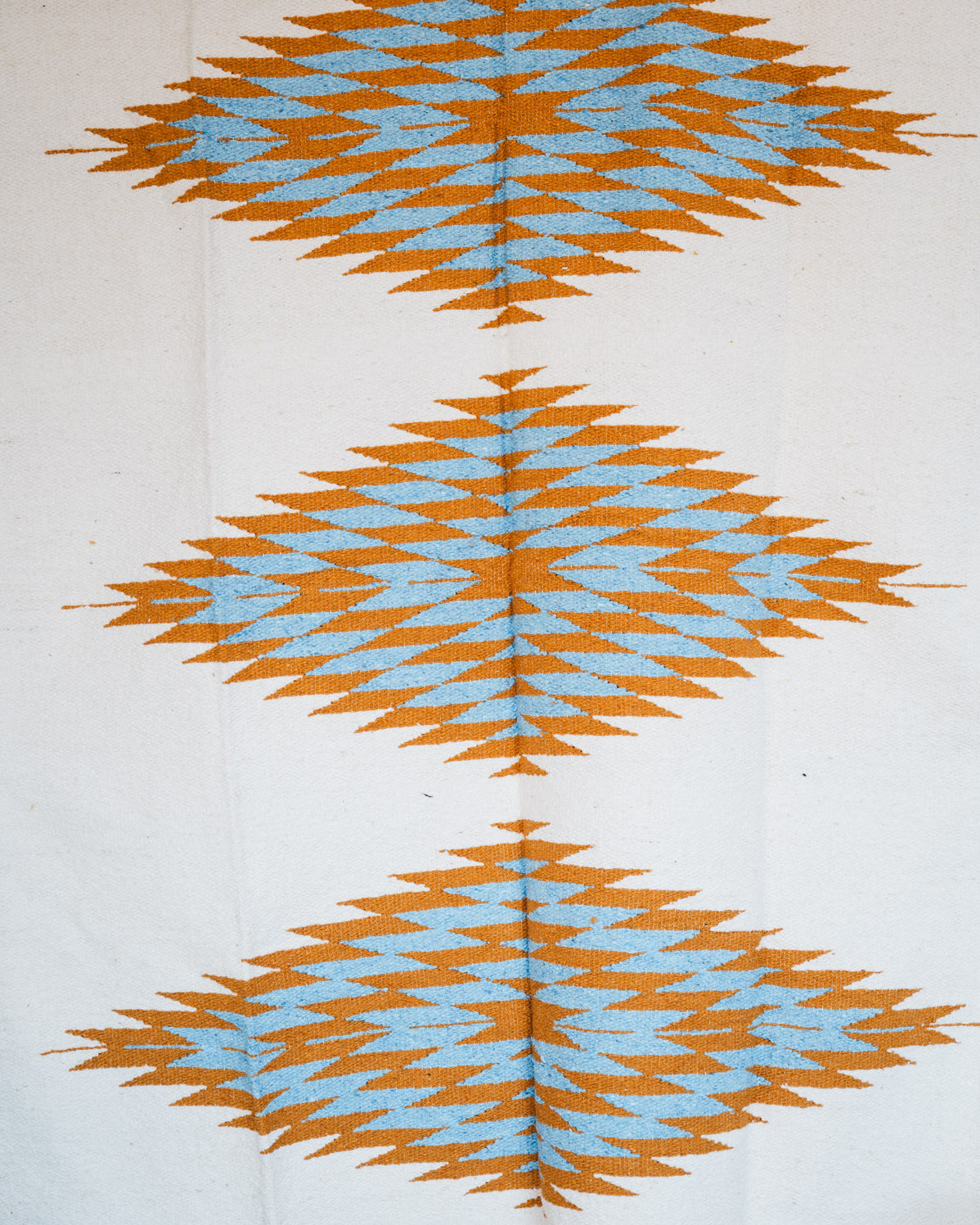 Handwoven Mexican Blanket Turquoise and gold color 3 Diamond pattern in modern industrial setting
