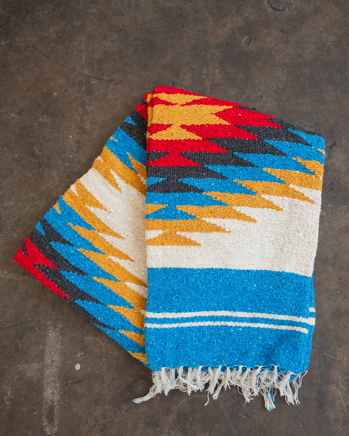 Red and yellow and blue southwestern diamond handwoven blanket folded