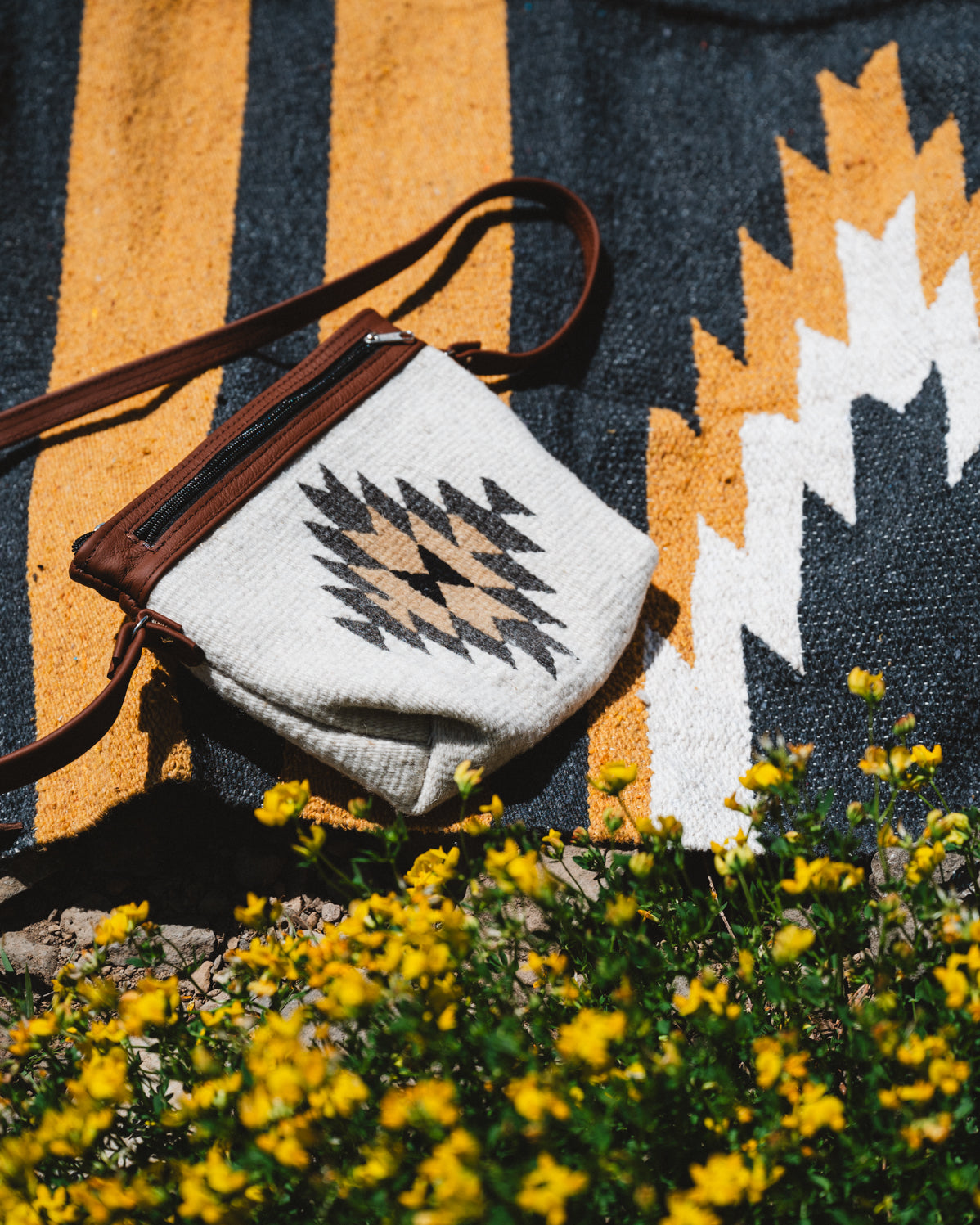 yellow zapotec diamond wool purse laying on relampago design mexican blanket