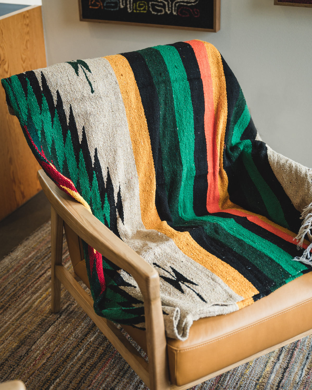 chair wrapped with multi color diamond handwoven mexican blanket