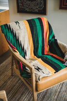 chair wrapped with multi color diamond handwoven mexican blanket
