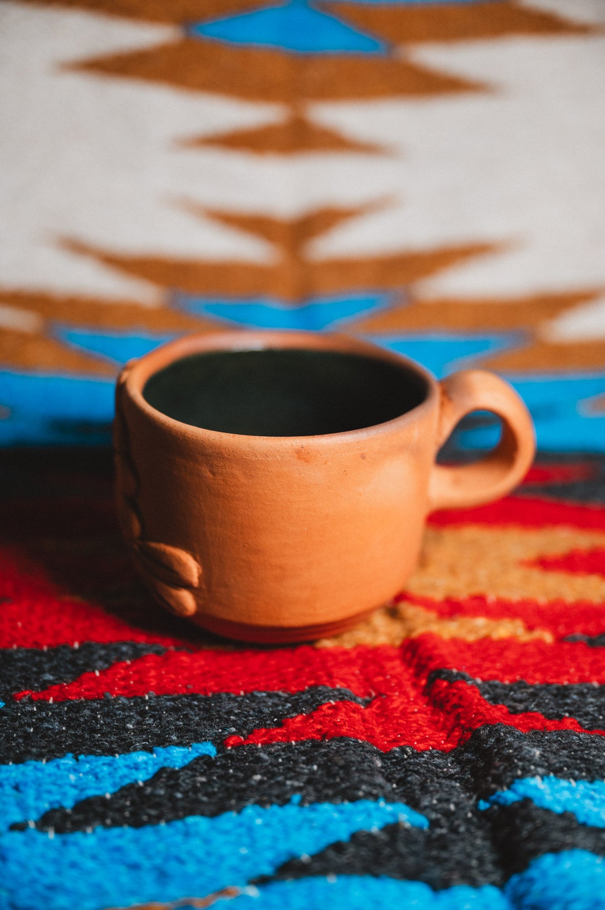 Ceramic mug on a colorful patterned fabric