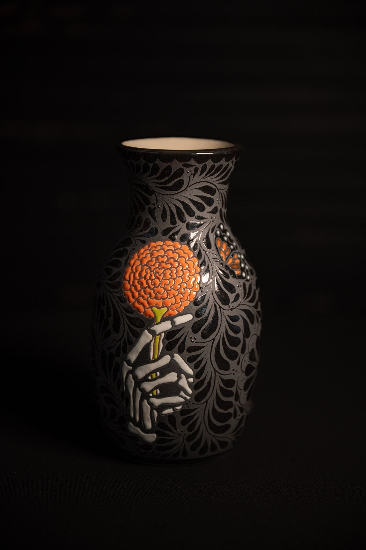 Day of the dead talavera vase featuring monarch and skeleton hand holding a marigold