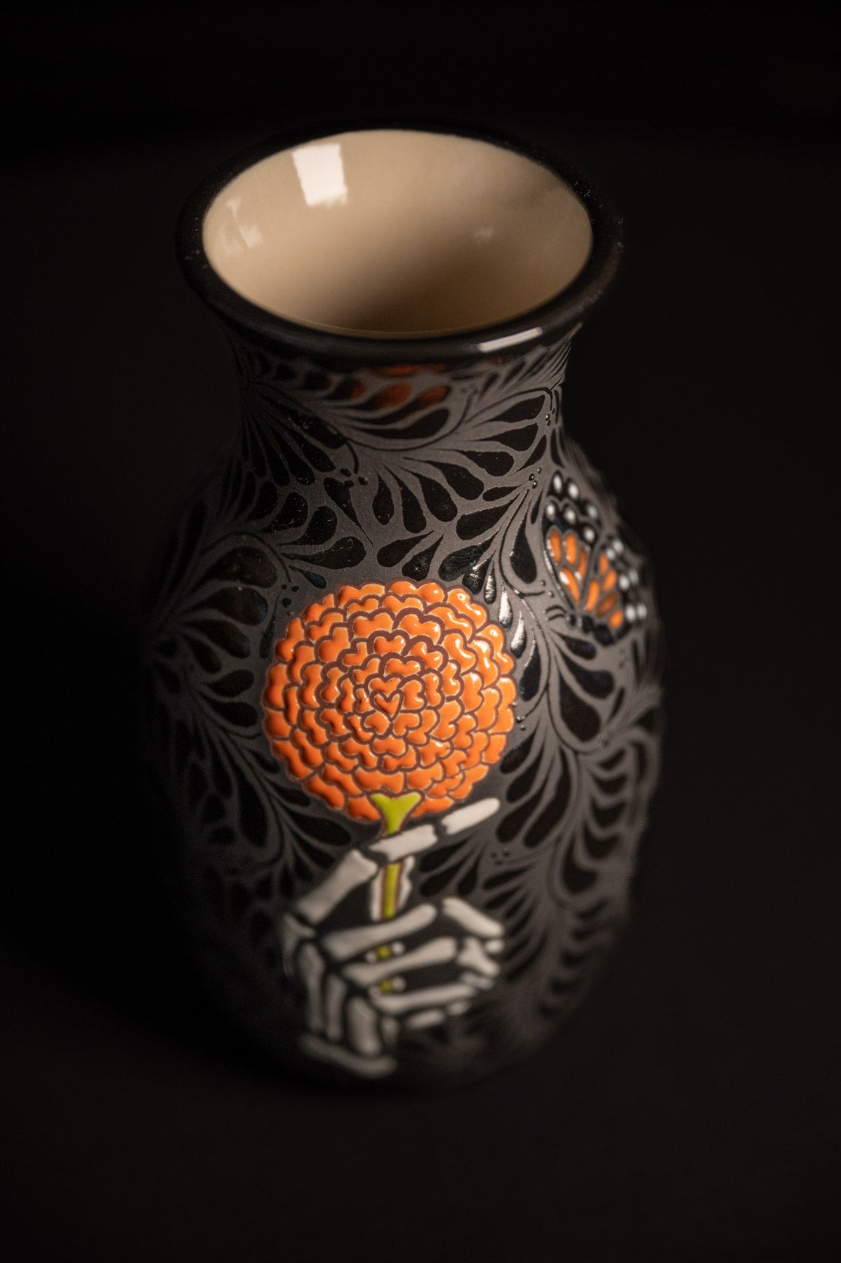 Day of the dead talavera vase featuring monarch and skeleton hand holding a marigold