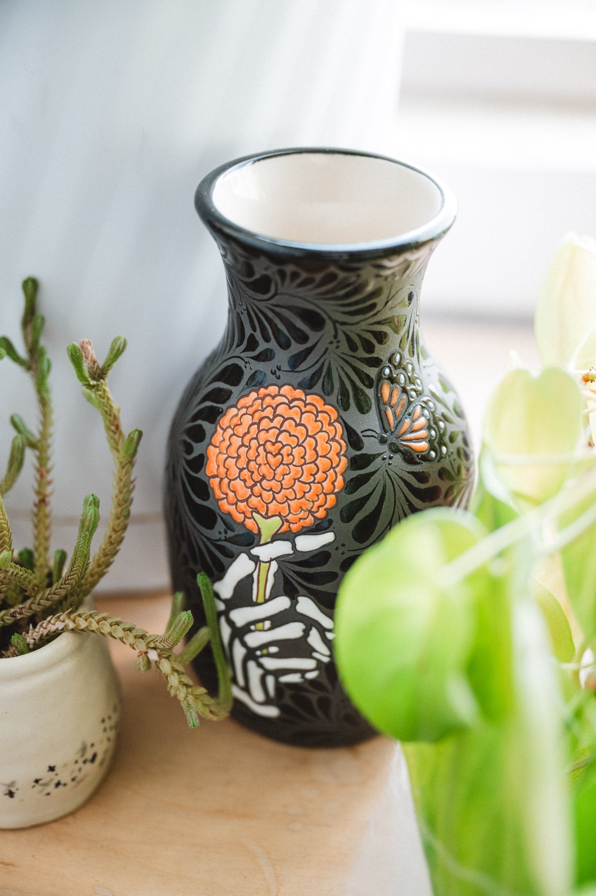 Day of the dead talavera vase featuring monarch and skeleton hand holding a marigold