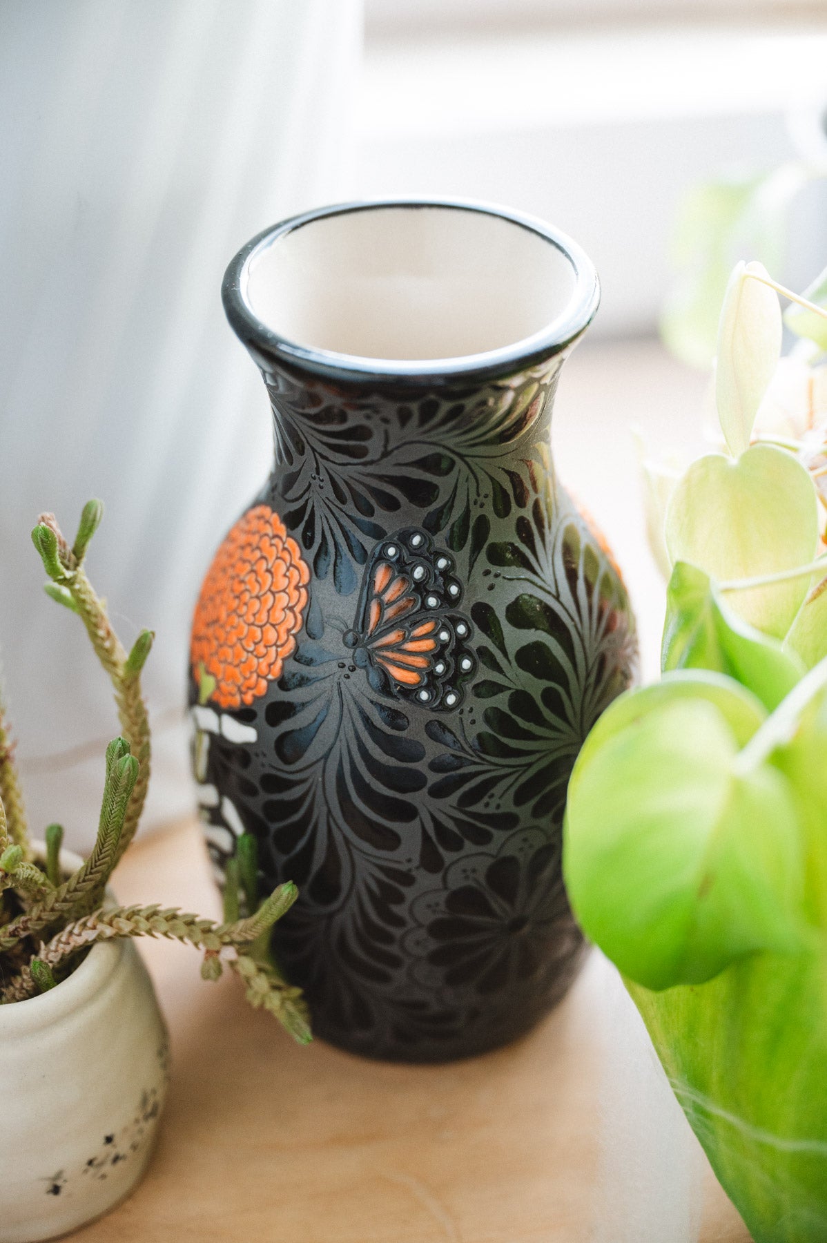 Day of the dead talavera vase featuring monarch and skeleton hand holding a marigold