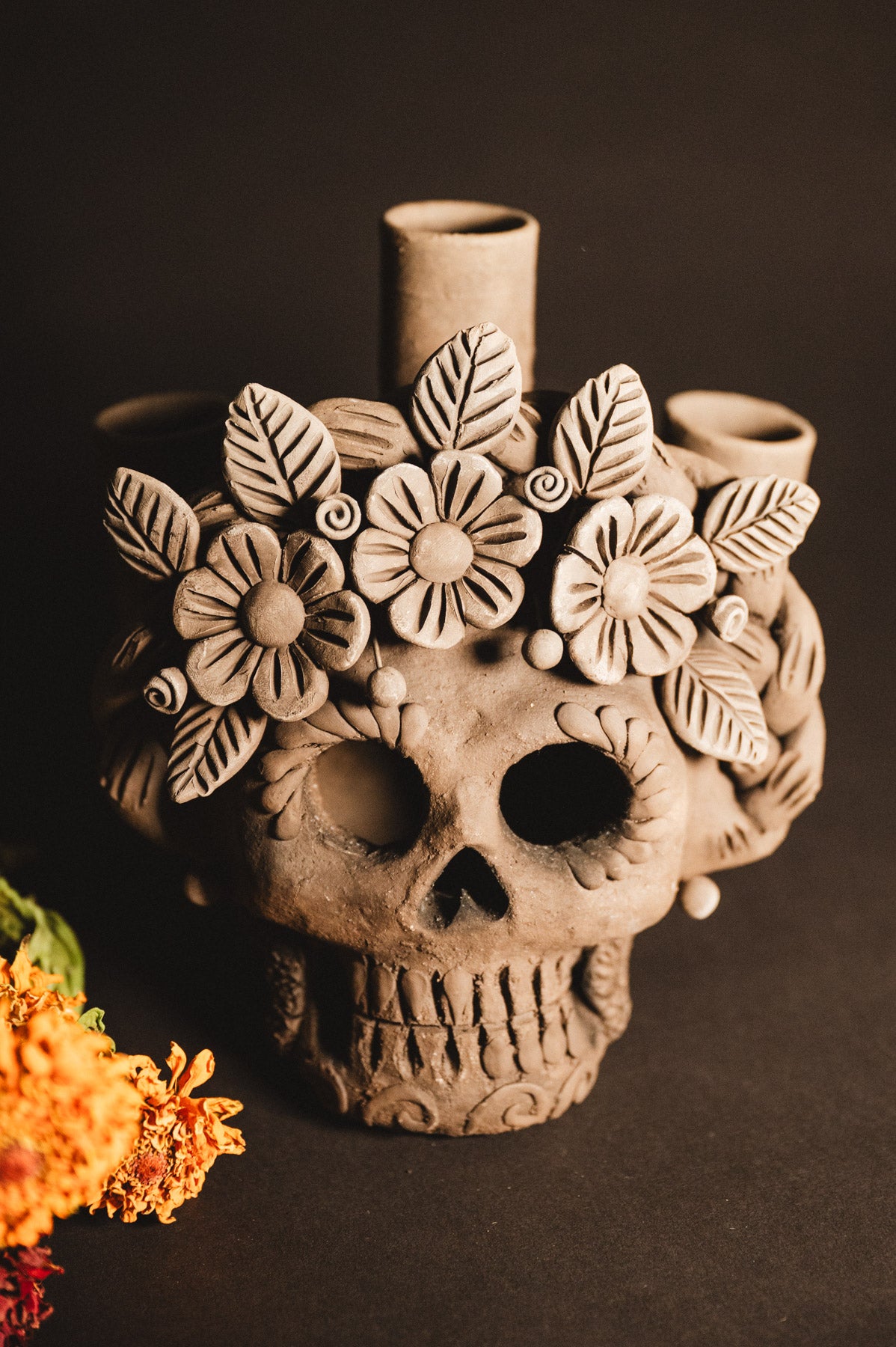 Ceramic skull with floral designs on a dark background