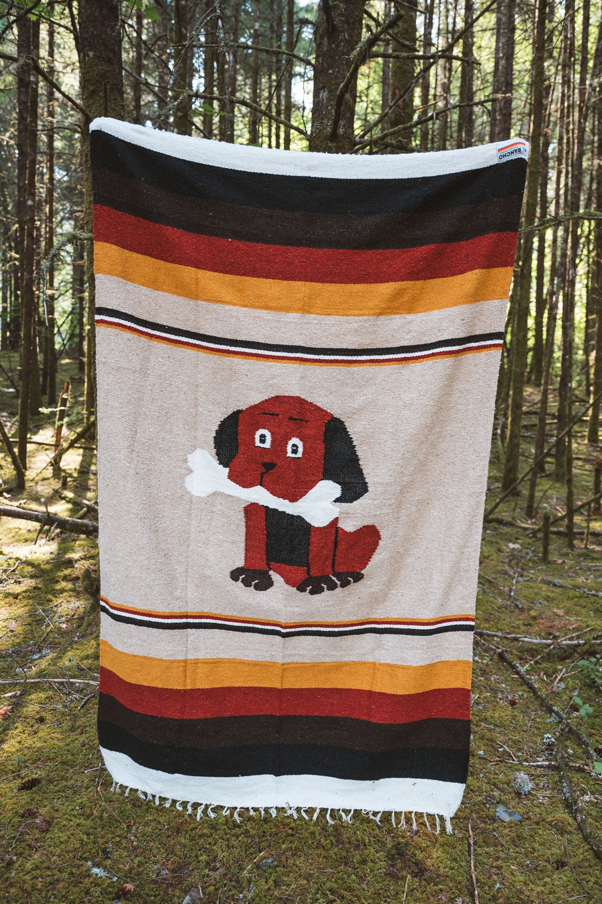 Dog themed handwoven mexican blanket in a forest background