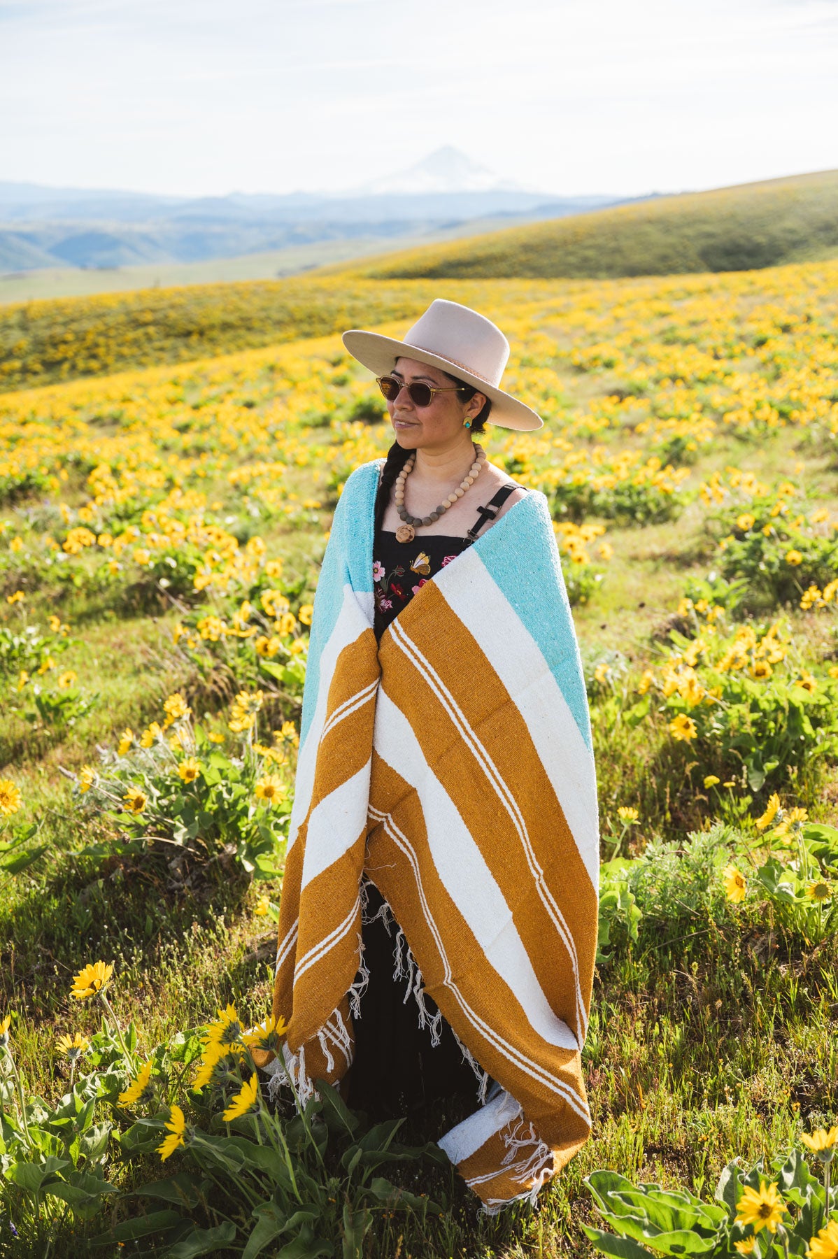 Person standing in a field of wildflowers wearing a striped towel