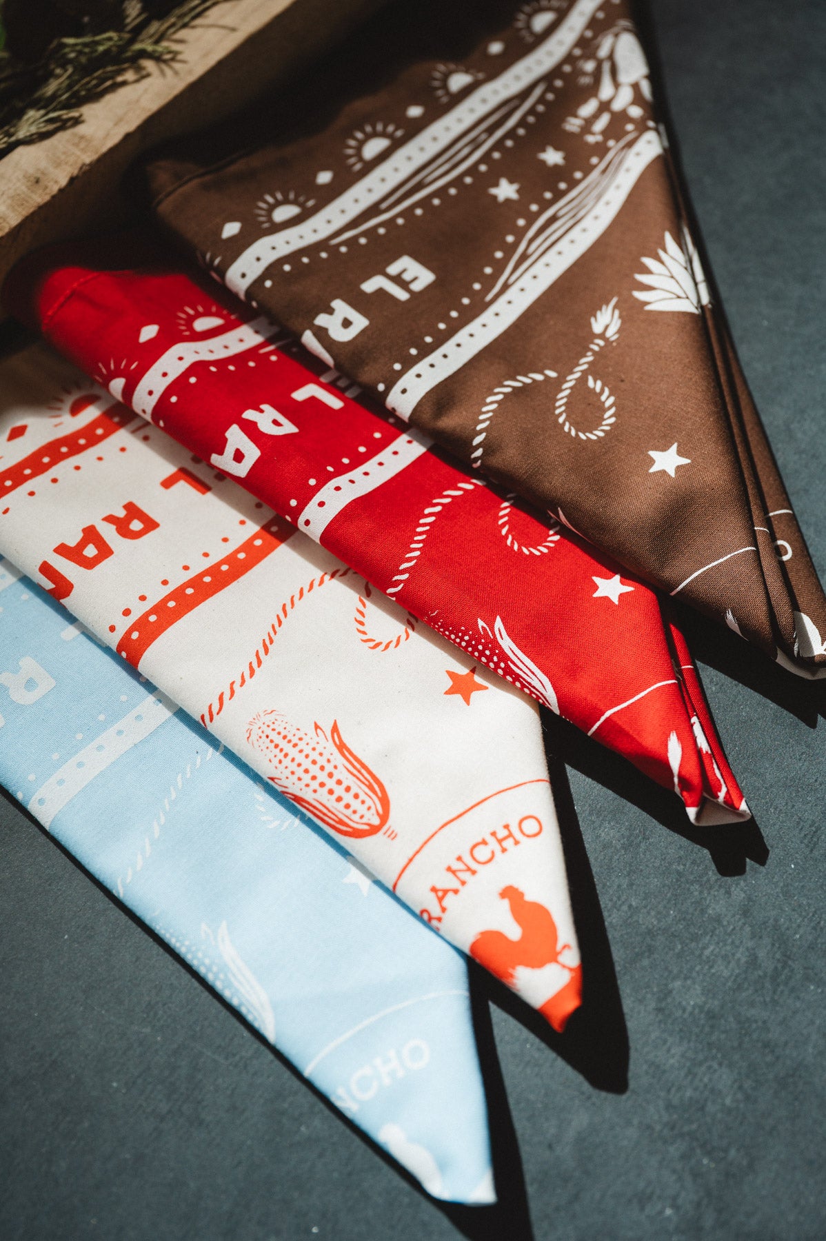Three patterned bandanas in red, white, and blue on a dark surface.