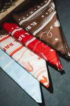 Three patterned bandanas in red, white, and blue on a dark surface.