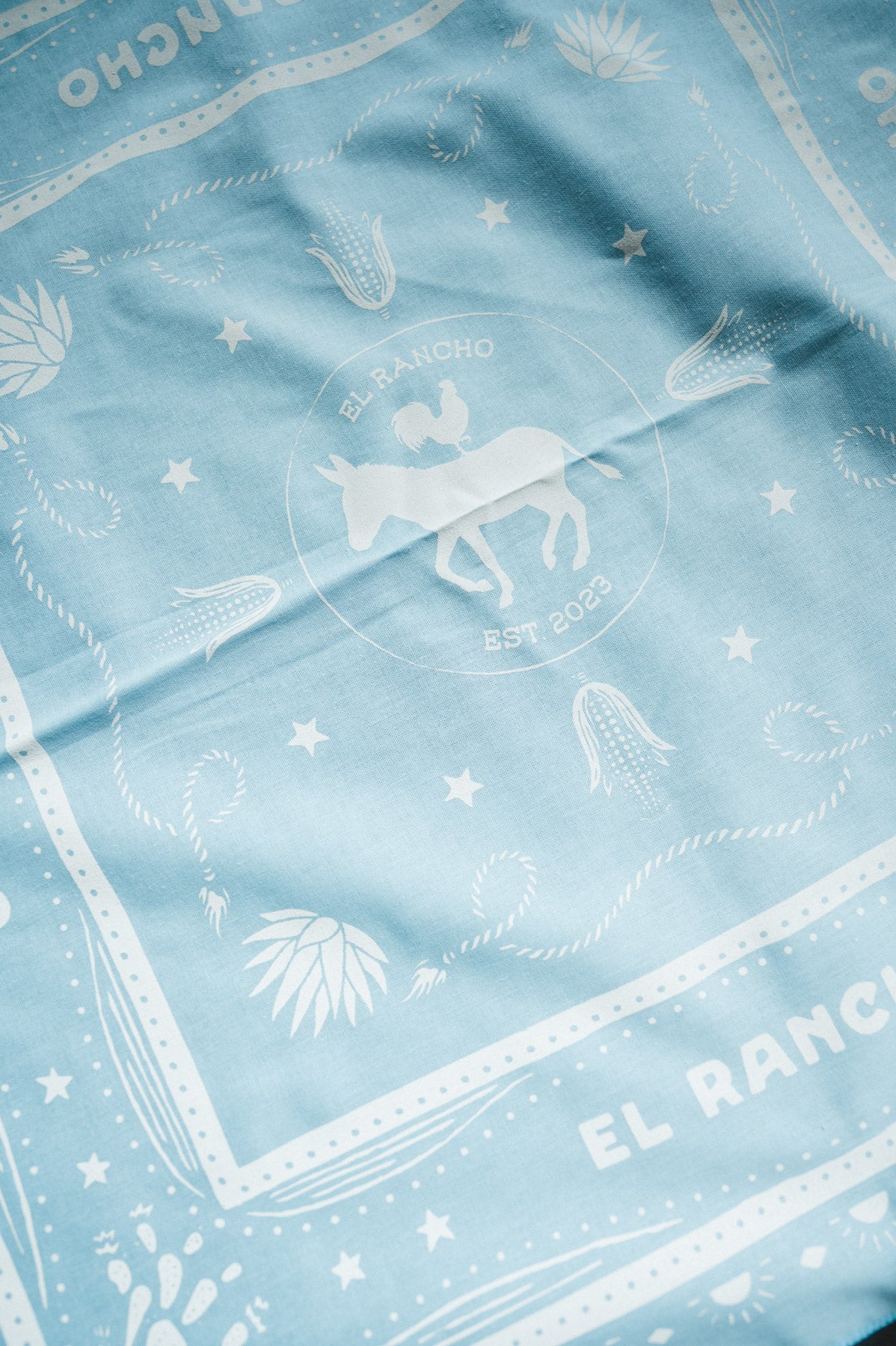 Light blue fabric with white patterns and 'El Rancho' branding
