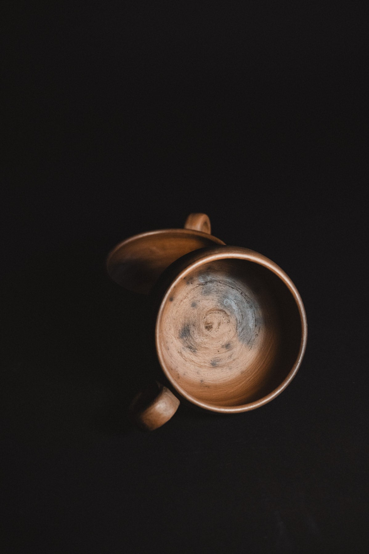 Ceramic mug with a dark interior on a black background