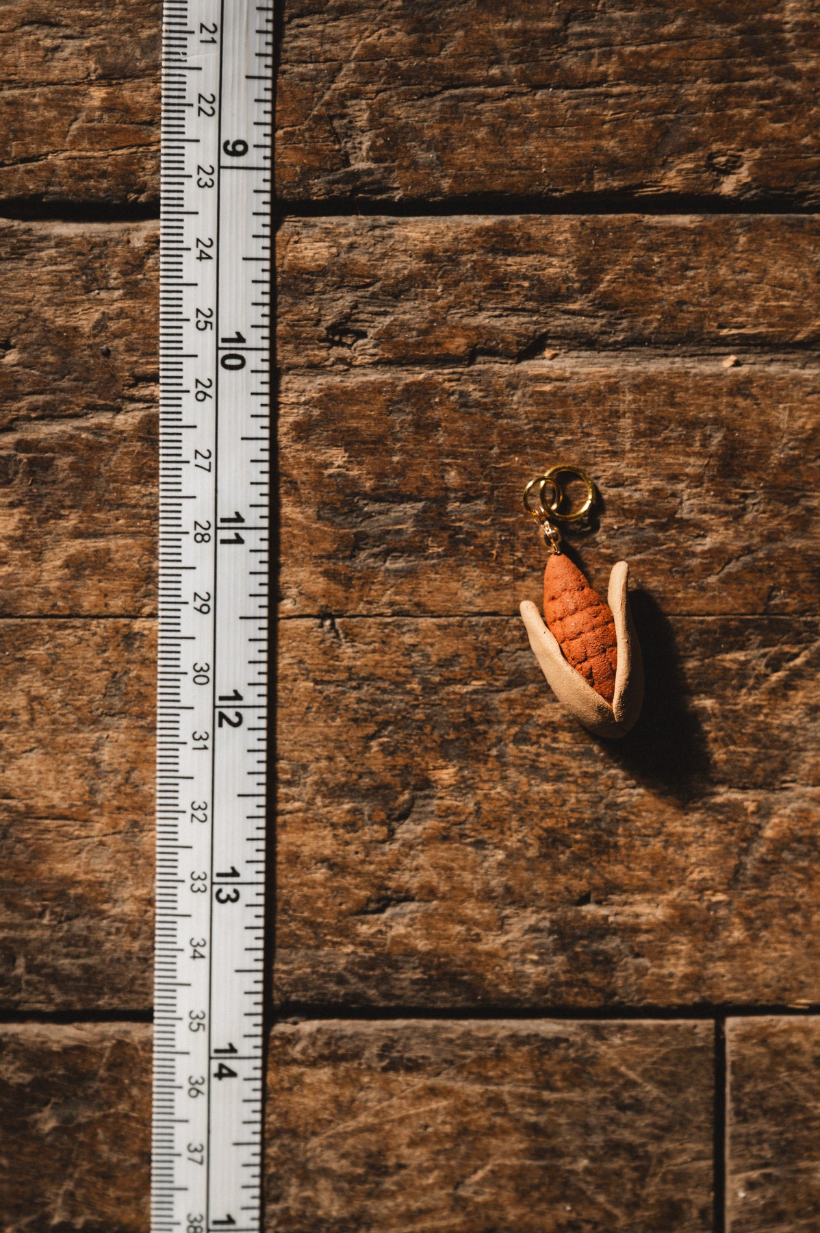Elote clay pendant on wood floor