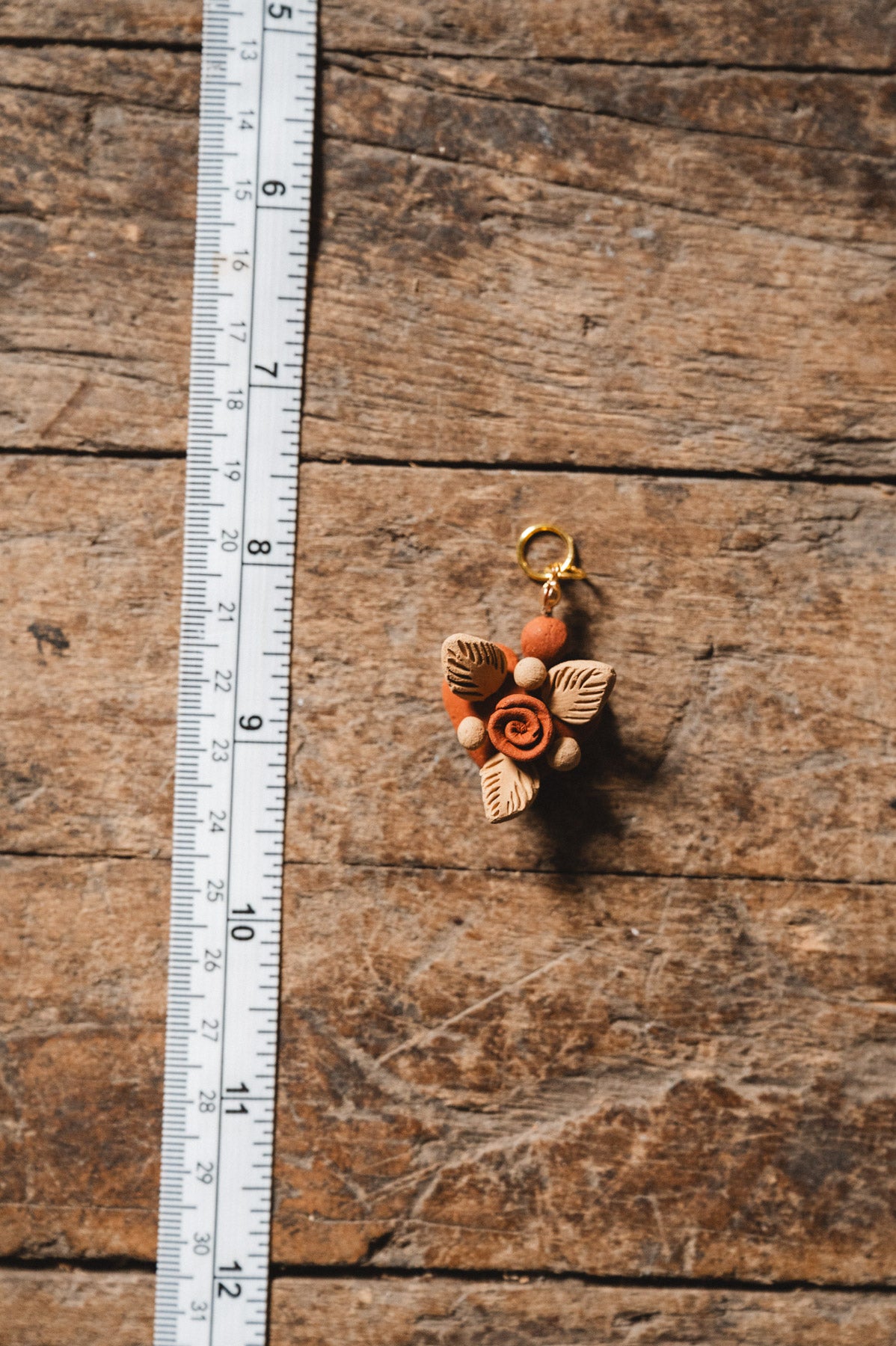 Filigrana heart pendant on wooden floor with ruler