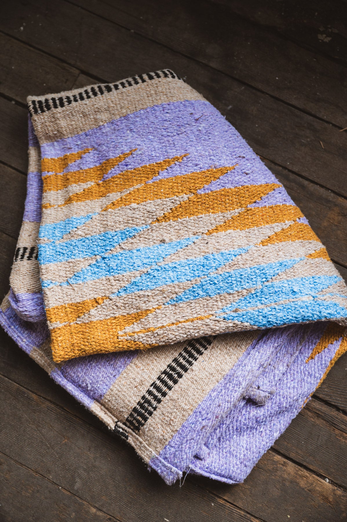 Woven fabric with a colorful pattern on a wooden surface