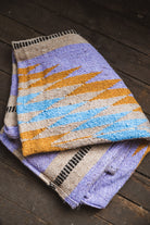 Woven fabric with a colorful pattern on a wooden surface