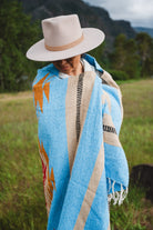Mexican woman wrapped in blue handwoven mexican blanket
