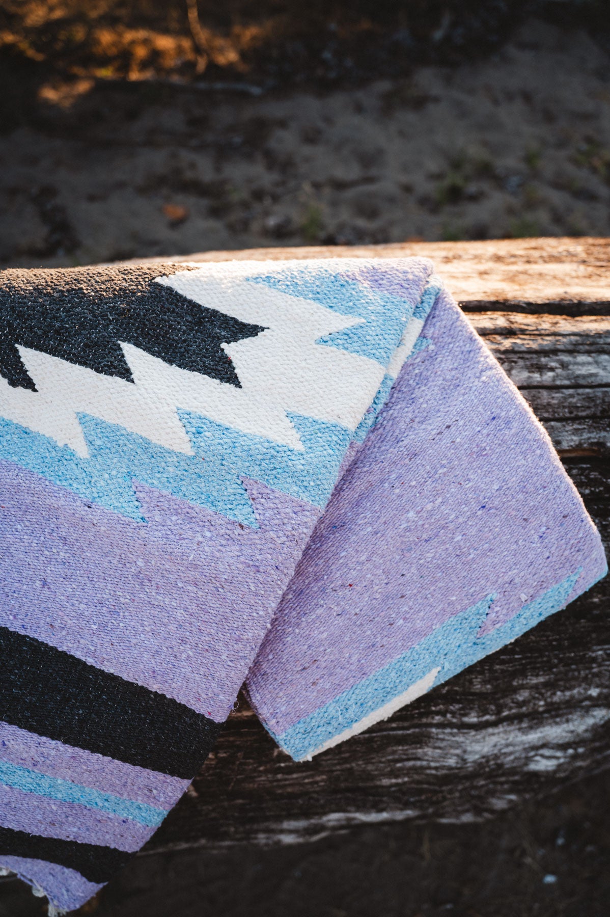 Colorful patterned rug with geometric design on a wooden surface