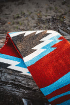 Colorful patterned rug with geometric design on a wooden surface