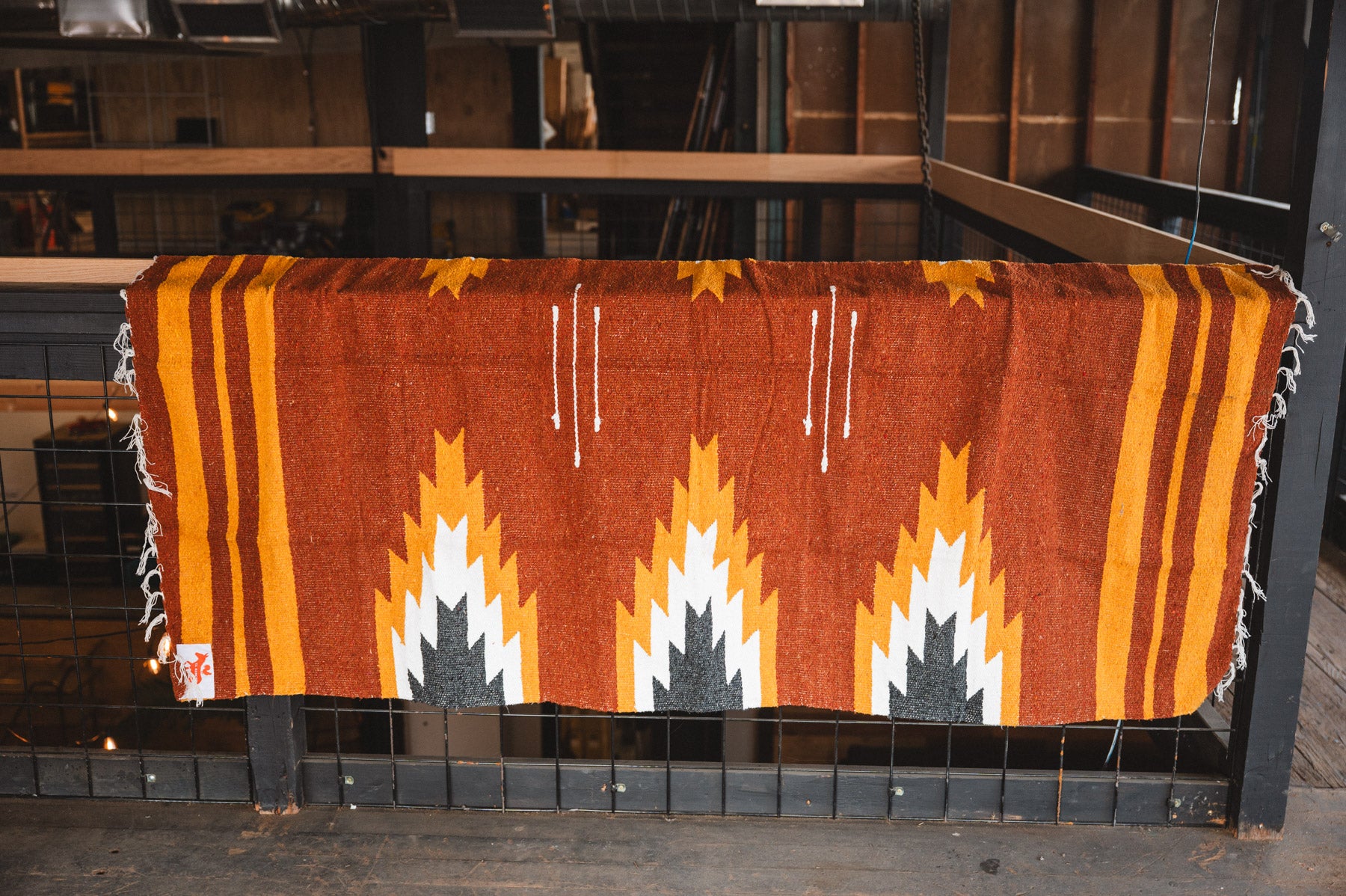 Woven blanket with geometric pattern on a wooden surface