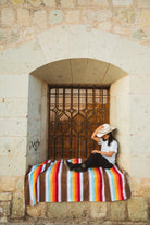 Santo Domingo Church Oaxaca and a girl sitting on a handwoven mexican blanket in front of it
