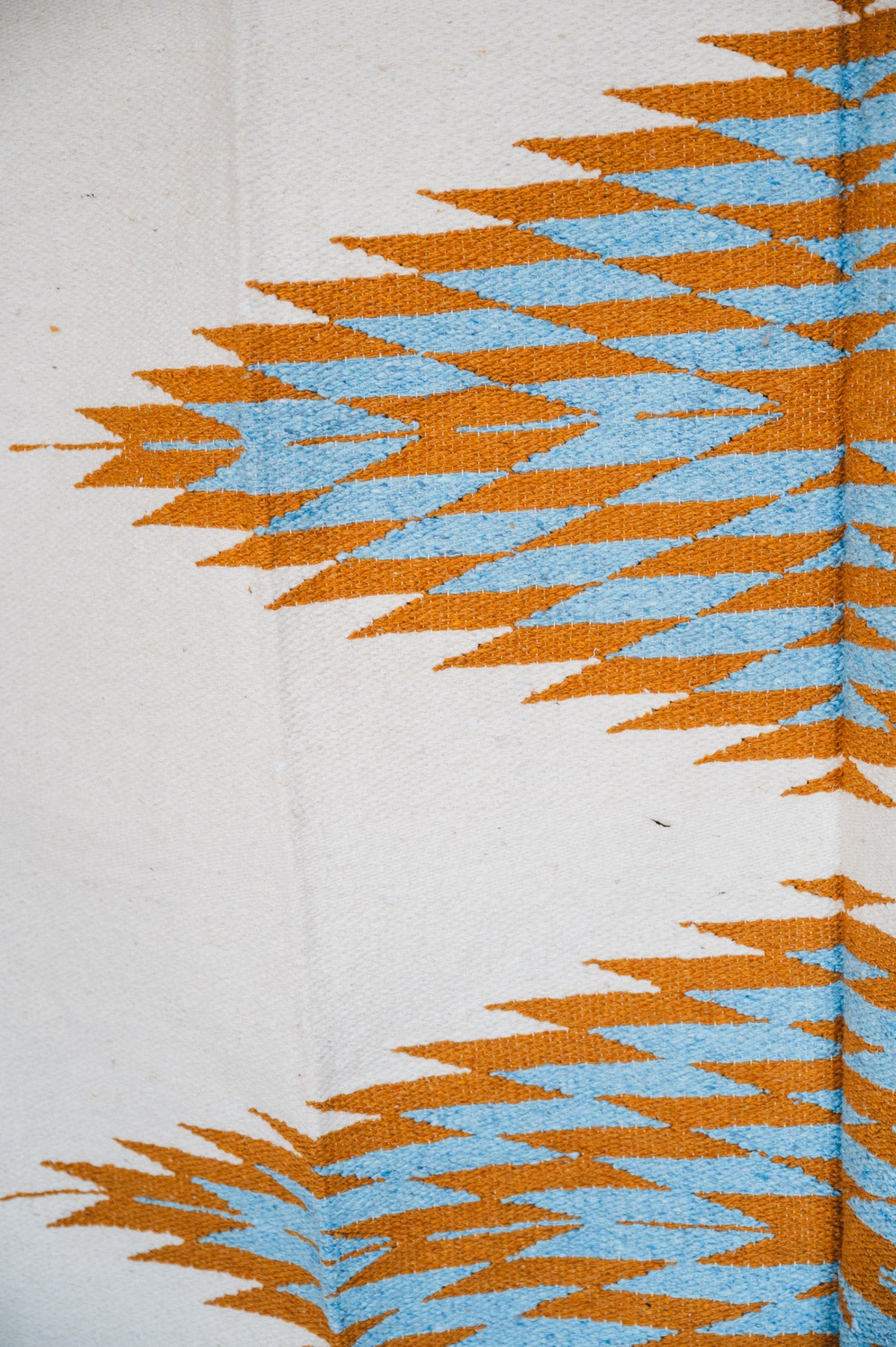 Handwoven Mexican Blanket Turquoise and gold color 3 Diamond pattern in modern industrial setting