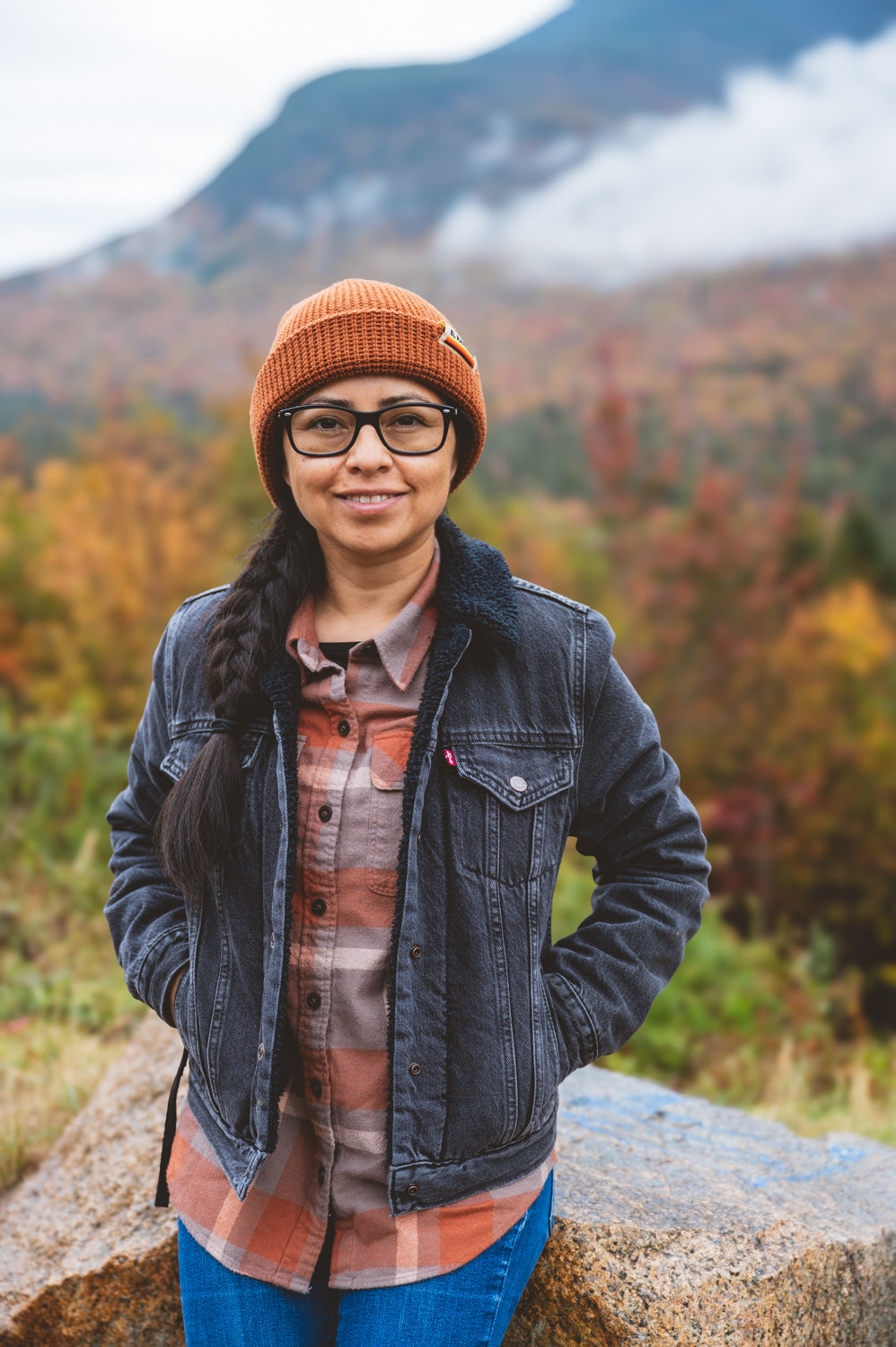Girl wearing a red beanie in the mountains during autumn