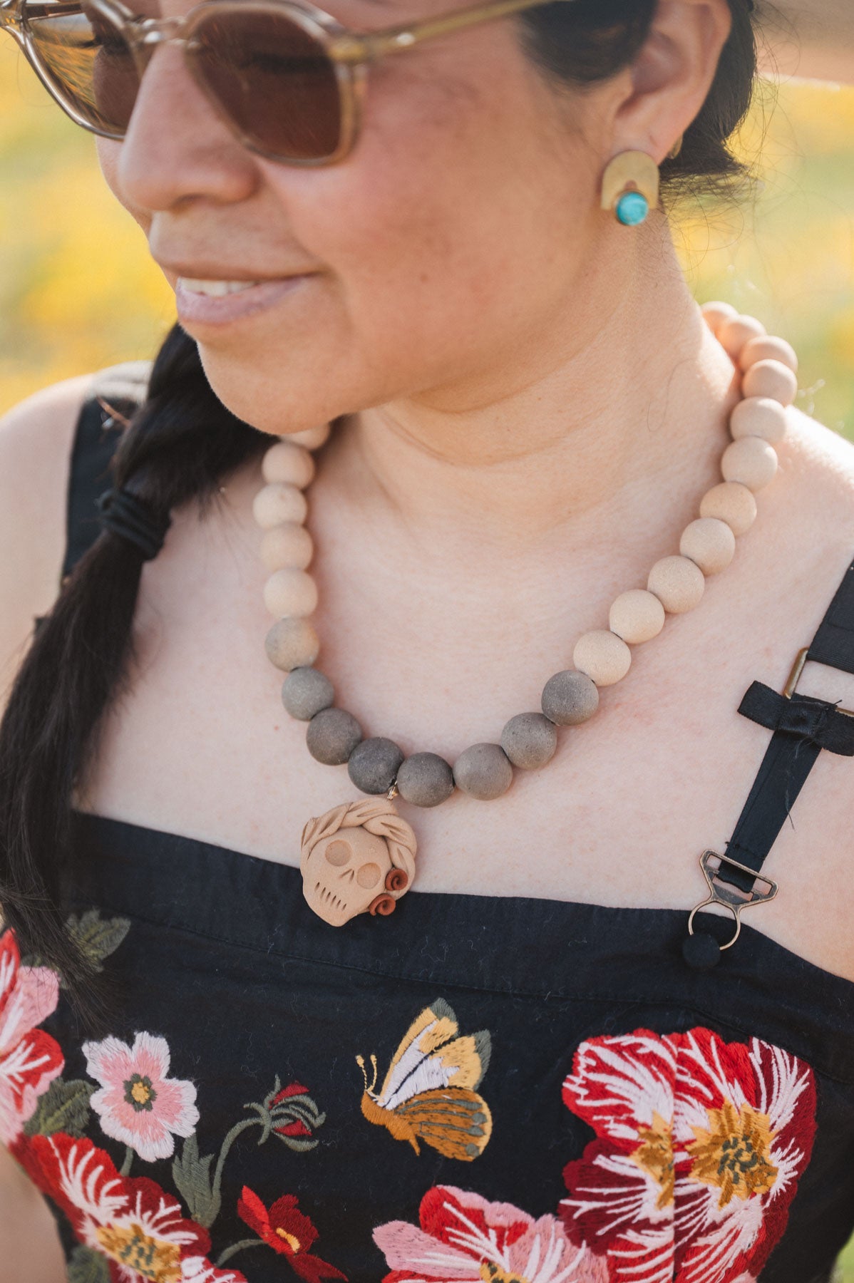 Woman wearing a clay catrina necklace from oaxaca