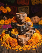 Mezcal copitas of barro negro with marigolds in dia de los muertos setting